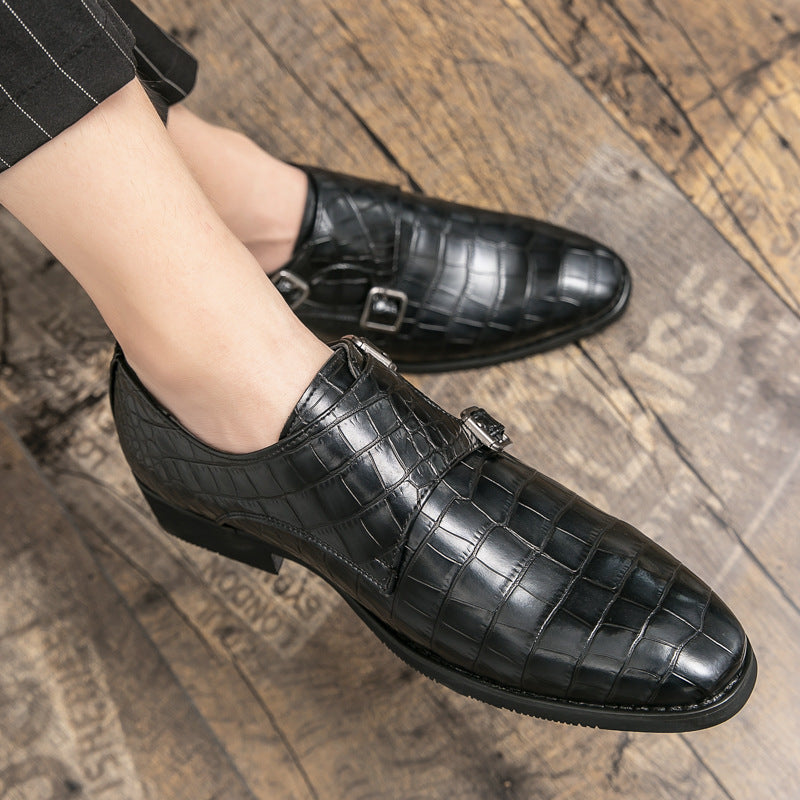 Black leather shoes with buckle detail on a wooden floor