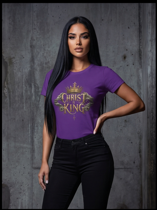 Woman wearing a purple t-shirt with 'Christ King' text against a gray concrete wall.
