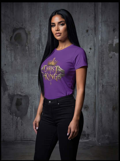 Woman wearing a purple t-shirt with 'Christ King' design against a textured wall.