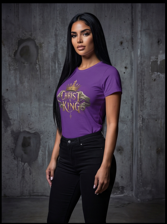 Woman wearing a purple t-shirt with 'Christ King' design against a textured wall.